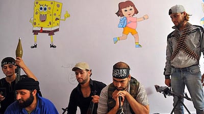 Fighters from the Syrian opposition rest at a primary school in the centre of Aleppo. Bulent Kilic / AFP Photo