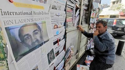 A vendor arranges magazines as newspapers report the death of Osama bin Laden in Beirut, Lebanon.