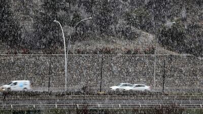 Vehicles drive on a road during heavy snowfall in Ankara. AFP