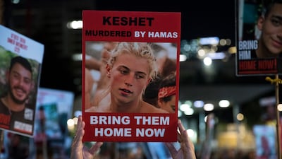 People hold signs and photos in Tel Aviv at a rally calling for the release of hostages held by Hamas in Gaza. Getty Images