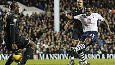 Tottenham's Jermain Defoe, in white, scores against his former club Portsmouth. The match ended 1-1.