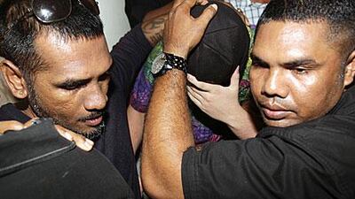 Indonesian security guards escort a 14-year-old Australian boy from court in Bali last week after he was sentenced to two months in jail for buying marijuana on the resort island of Bali.