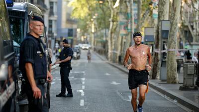 Normality, yet anything but. A jogger passes armed police in Las Ramblas, Barcelona, Spain, on Friday, August 18, 2017, the morning after a man ploughed into pedestrians, killing 13 people and injuring more than 100. Manu Fernandez/ AP