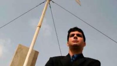 Munawar Kapadia of Kapadia Enterprises stands in front of wind turbine in Karachi, Pakistan.
