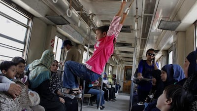 A girl uses hand grips to swing inside a female-only metro car, in Cairo, Egypt.