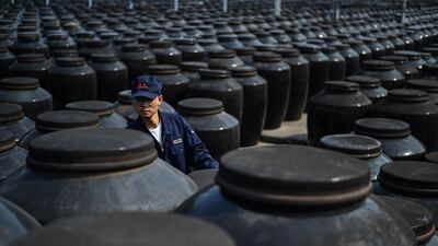 A worker checks rice vinegar stored in large jars at a plant in Zhenjiang, in China's eastern Jiangsu province. Hector Retamal/ AFP