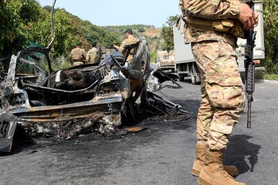 Lebanese soldiers stand next to a car that was hit in an Israeli drone strike in Abu Al Aswad, southern Lebanon, on May 17, 2025. AFP