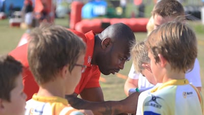 England international Ugo Monye interacts with children during his visit to the Etihad Airways Abu Dhabi Harlequins Junior Rugby tournament at Zayed Sports City in Abu Dhabi on Saturday. Ravindranath K / The National
