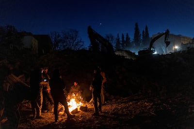 Earthquake survivors gather around a fire in Kahramanmaras, southern Turkey. Reuters