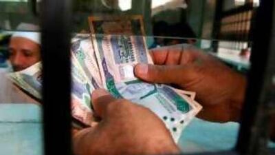 A money exchanger counts Saudi Riyals in Riadh.