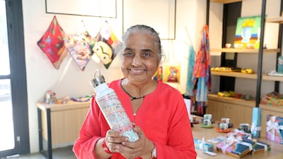 Rekha Kirpalani, one of Mawaheb studio's oldest students, with her artwork printed on a water bottle. Pawan Singh / The National