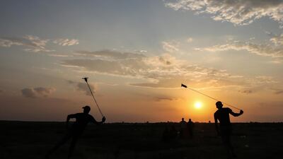 Palestinian protesters hurl stones during clashes after the weekly Friday protests near the border between Israel and the Gaza Strip. EPA