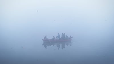 People ride a boat in the waters of river Yamuna on a cold and foggy winter morning in New Delhi, India. Reuters