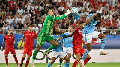 Manchester City goalkeeper Ederson punches the ball away. AFP