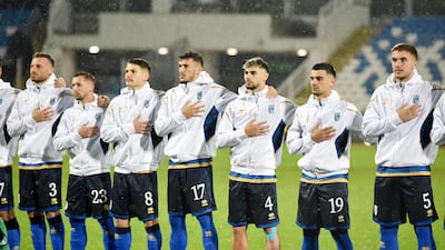 Kosovo players line up during the national anthems before the match. Reuters
