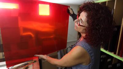 Husseini examines red glass to be used on one of her artworks in progress.