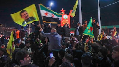 Residents celebrate the signing of a breakthrough deal between Syria's interim government and the SDF in Qamishli, north-eastern Syria. AP