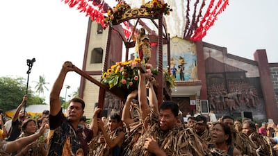 Devout Catholics carry a statue of St John the Baptist during the mud festival at Bibiclat