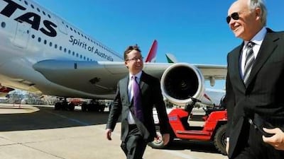 Qantas chief executive Alan Joyce (C) and Emirates president Tim Clark (R) walk past a Qantas aircraft at Sydney Airport. Greg Wood / AFP
