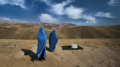 Two women walk along road in burquas. Courtesy Lynsey Addario