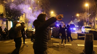 Protesters throw objects at a police vehicle during a protest against the arrest of Catalan rap singer Pablo Hasel, in Barcelona, Spain on February 18, 2021. Reuters