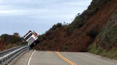 This photo provided by the California Department of Transportation shows a Caltrans dump truck that was nearly toppled by a mud slide along California Highway 1 in Mendocino County, California. The highway is closed indefinitely after the overnight slides. California Department of Transportation via AP