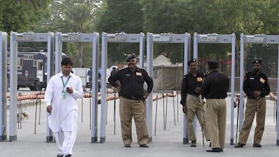 Policemen stand near the security scanner gate on Tuesday outside Gaddafi Stadium ahead of the cricket series between Pakistan and Zimbabwe in Lahore. Mohsin Raza / Reuters