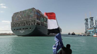 A picture released by Egypt's Suez Canal Authority shows a man waving the Egyptian flag after Panama-flagged MV 'Ever Given' container ship was fully dislodged from the banks of the Suez. AFP