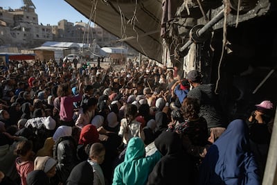 Displaced people jostle to buy bread amid severe shortages in Khan Younis, caused by Israeli restrictions on deliveries of imports and aid into Gaza. EPA