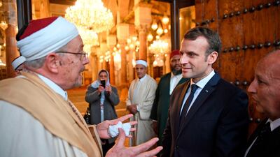 French President Emmanuel Macron speaks with a cleric as he visits the Zitouna mosque in the old town of Tunisian capital Tunis on February 1, 2018, during his first state visit to the former French colony. Eric Feferberg / AFP