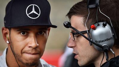 Lewis Hamilton talks to a Mercedes team member on Sunday at the Belgian Grand Prix. Ben Stansall / AFP / August 24, 2014
