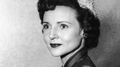 Betty White, in a veiled hat and striped dress, poses for a headshot in 1955. Getty Images