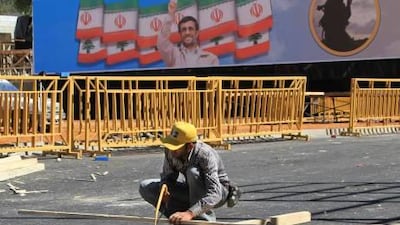 A man works in front of a poster of the Iranian president Mahmoud Ahmadinejad during preparations for his visit to Lebanon.