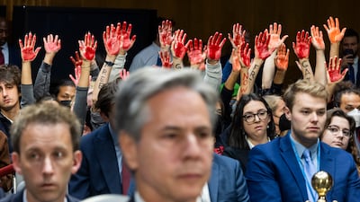 Protesters calling for a ceasefire in Gaza raise their arms as US Secretary of State Antony Blinken testifies at a Senate review of national security requests in Washington. EPA