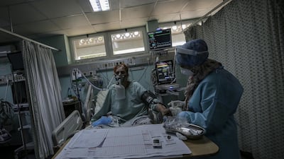 Members of the clinical staff wearing Personal Protective Equipment (PPE) care for a patient with coronavirus in the intensive care unit at the European Hospital, east of Rafah town, southern Gaza strip, 30 November 2020. The European Hospital, which has been classified as the Epidemiology Hospital since the start of the coronavirus in the Gaza Strip on 25 August 2020, has 334 infected cases under clinical care including 109 severe and critical cases. The production capacity of oxygen is 2,200 liters per minute, and there has become a large deficit after the increasing number of infections with Coronavirus. EPA/MOHAMMED SABER