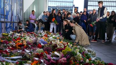 People lay flowers to honour victims killed in a terror attack at a shopping centre in Denmark. AP Photo