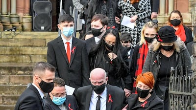 David Lewis, centre, husband to Gladys and father to Darren and Dean Lewis, is helped out of church by mourners during the funeral of Gladys, Dean, and Darren at St Peter's Church in Pentre, South Wales. Mrs Lewis and her two sons all died of Covid-19 within five days of each other. Getty Images