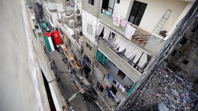 A picture taken on December 21, 2017 shows a Palestinian flag hanging next to a makeshift Turkish flag from buildings across a street in the Burj Al Barajneh camp. ANWAR AMRO / AFP