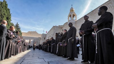 Franciscan monks wait outside the Church of the Nativity in Bethlehem. AFP