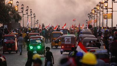 Demonstrators and tuk-tuk drivers are seen on a bridge in Baghdad. Reuters