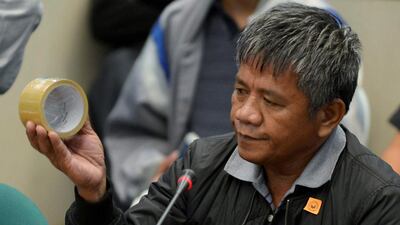 Edgar Matobato, a self-confessed former hitman, holds up a roll of tape of the type he claims he used on his victims, during a September 15, 2016, senate hearing on drug-related extrajudicial killings, in Pasay city Metro Manila, Philippines. Ezra Acayan / Reuters