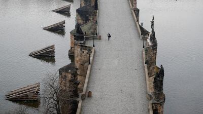 A woman walks across the near empty Charles Bridge in Prague, Czech Republic. AP Photo