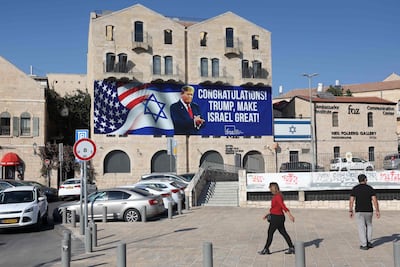 Israelis walk past a billboard congratulating US Republican presidential candidate and former president Donald Trump in Jerusalem. (Photo by AHMAD GHARABLI / AFP)