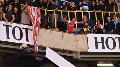 Arsenal fans celebrate the team's win over Spurs in the League Cup on Wednesday night and dismantle a sign at White Hart Lane. Ben Stansall / AFP