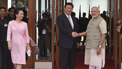 Indian Prime Minister Narendra Modi, right, poses with Chinese President Xi Jinping as he welcomes him upon his arrival at a hotel in Ahmadabad, India, Wednesday, Sept. 17, 2014. Xi’s wife Peng Liyuan is on left. Xi landed in Modi’s home state of Gujarat on Wednesday for a three-day visit expected to focus on India's need to improve worn out infrastructure and reduce its trade deficit. (AP Photo/Ajit Solanki)