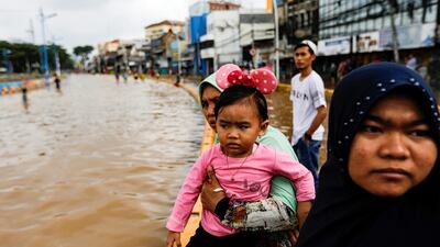 Locals look on after floods hit Jatinegara. Reuters