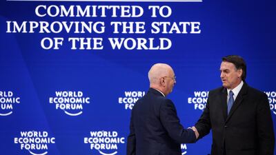 Brazilian President Jair Bolsonaro shakes hands with Davos founder Klaus Schwab. AFP