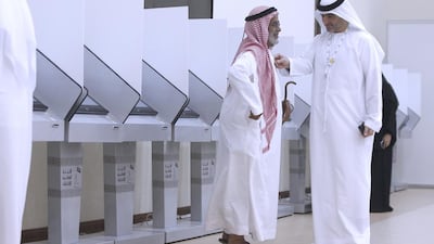 Voters at the Sharjah polling station cast their votes for the FNC election. Jeffrey E Biteng / The National