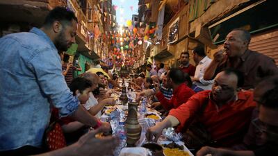 Residents of Ezbet Hamada in Cairo's Mataria district gather to eat Iftar, the meal to end their fast at sunset, during the holy fasting month of Ramadan in Cairo, Egypt. Reuters
