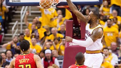 LeBron James #23 of the Cleveland Cavaliers dunks over Mike Scott #32 and Paul Millsap #4 of the Atlanta Hawks during the second half of the NBA Eastern Conference semifinals at Quicken Loans Arena on May 2, 2016 in Cleveland, Ohio. The Cavaliers defeated the Hawks 104-93. Jason Miller/Getty Images/AFP